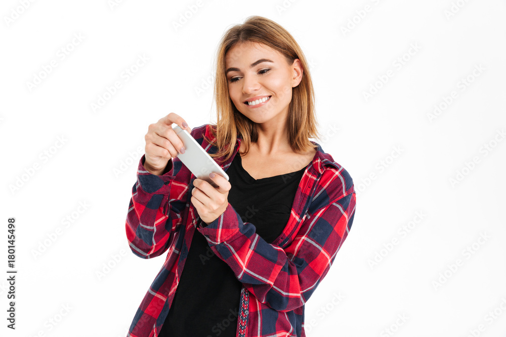 Portrait of a smilinf cheery girl playing games on phone