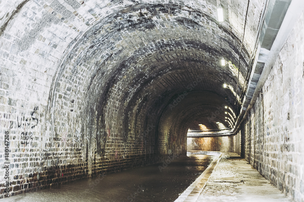 Naklejka premium Lumières dans un ancien tunnel en pierre