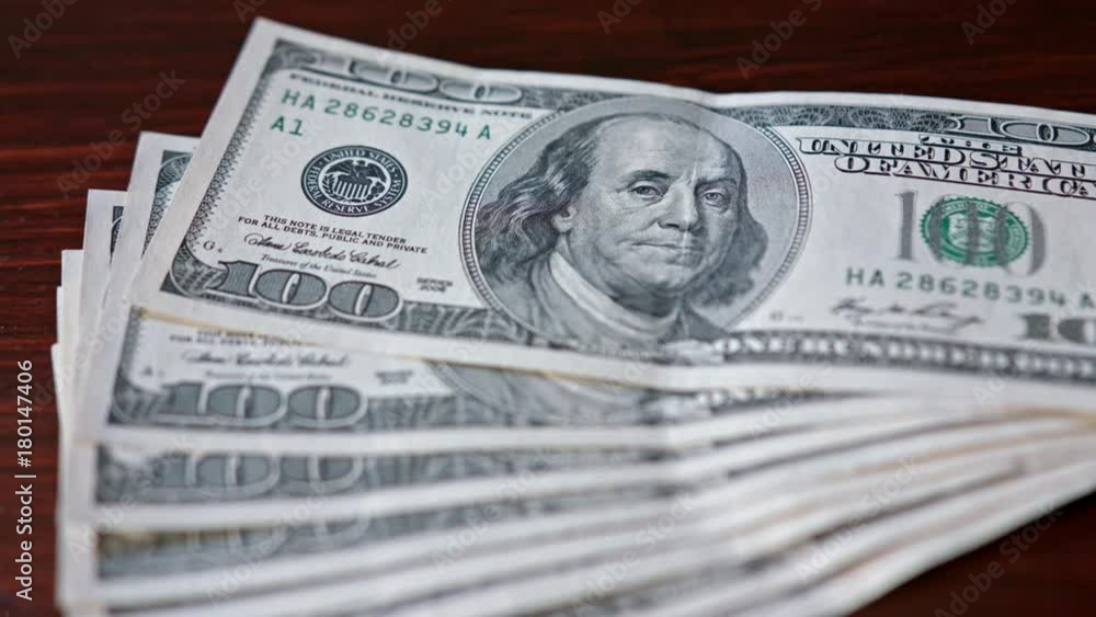 Fanned pile of hundred dollar banknotes on a table. Close-up shot Fanned pile of hundred dollar banknotes on a table. Close-up shot