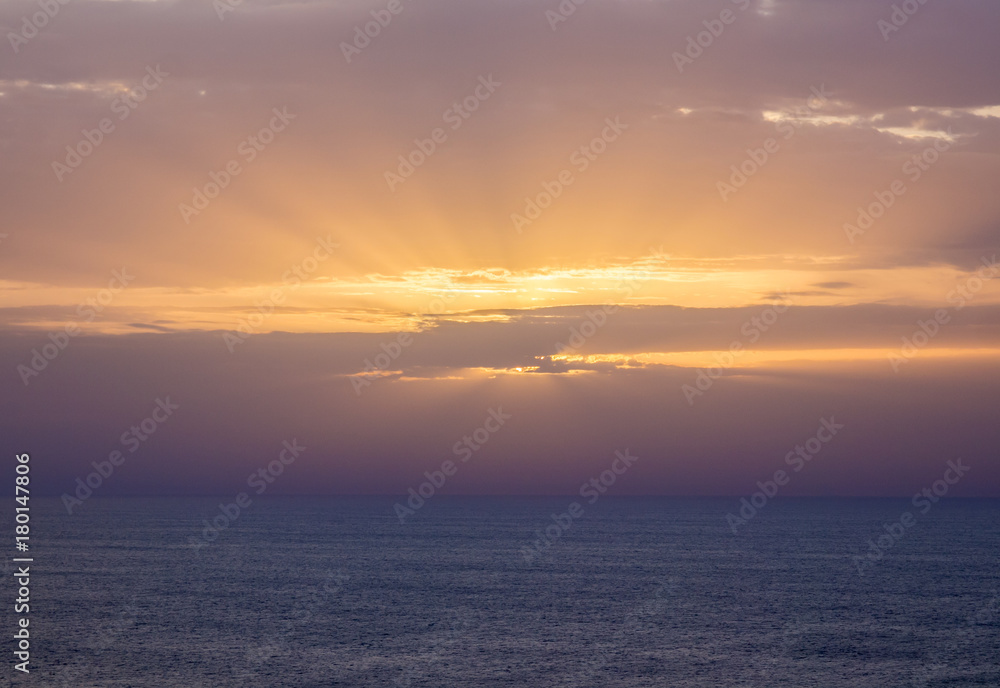 nice sunset with rays of light among the clouds over the sea in Sagres, Algarve, Portugal