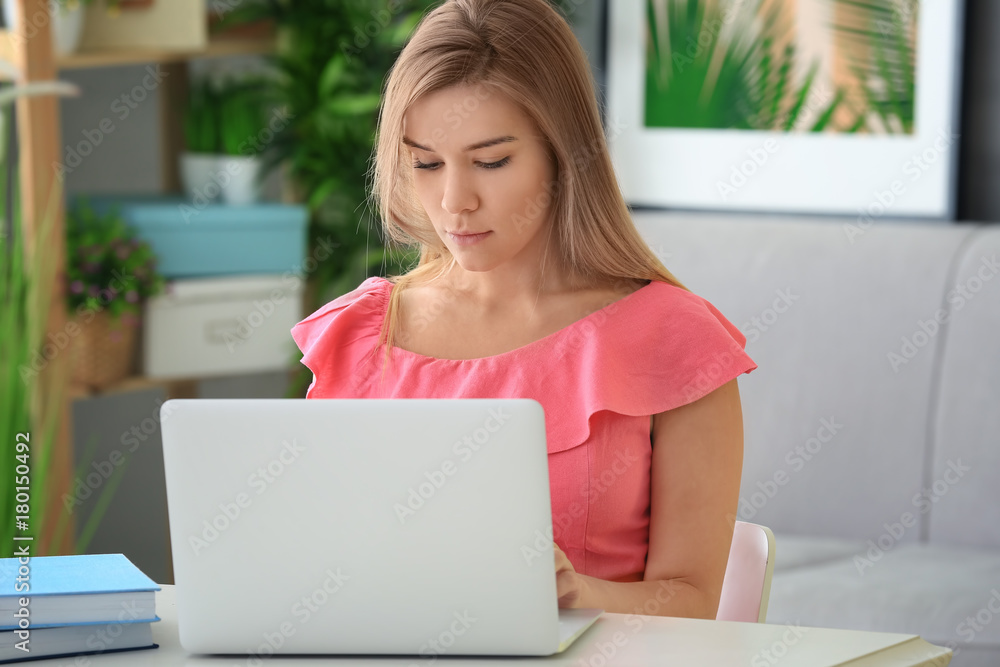 Beautiful young woman working on laptop at home Beautiful young woman working on laptop at home