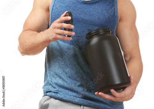 Sporty young man with jar of protein powder on white background photo