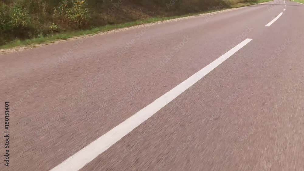 Movement of the vehicle in a two way road with white markings. Close up Movement of the vehicle in a two way road with white markings. Close up
