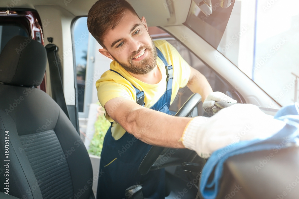 Man cleaning salon with rag in car Man cleaning salon with rag in car