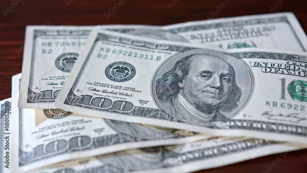 Fanned pile of hundred dollar banknotes on a table. Close-up shot Fanned pile of hundred dollar banknotes on a table. Close-up shot