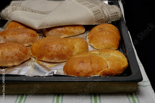 hot pies on a baking sheet covered with a napkin black background