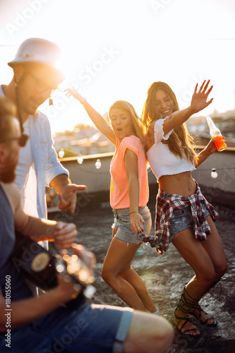 Group of happy friends having party on rooftop