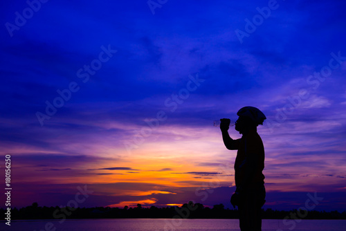 Silhouette of sport man drink water on sunset © reewungjunerr