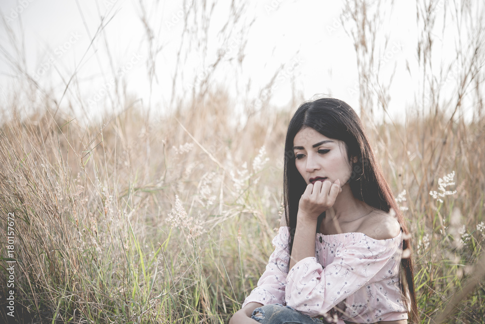 Close up of lonely woman alone in a field. Vintage filter style.Disappointed by love.Heartbroken from a lover.heartbreak girl concept Close up of lonely woman alone in a field. Vintage filter style.Disappointed by love.Heartbroken from a lover.heartbreak girl concept