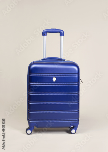 Blue trolley suitcase isolated on gray background