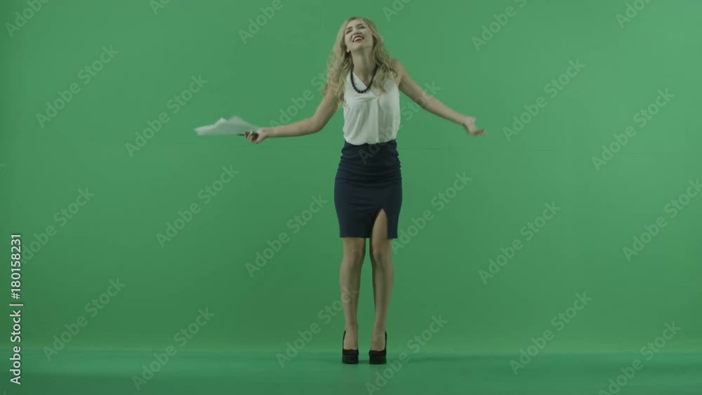 Young woman throwing papers and dancing in full body shot over chroma key Young woman throwing papers and dancing in full body shot over chroma key