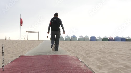 A girl walking on a sand beach access path