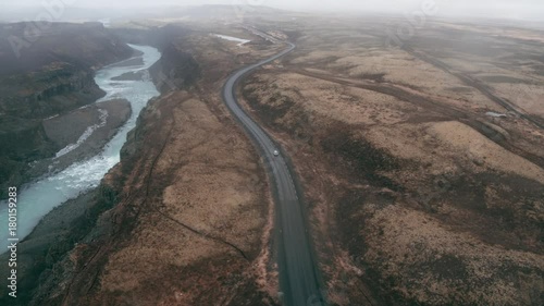Aerial view of car driving along Icelandic road and foggy landscape 