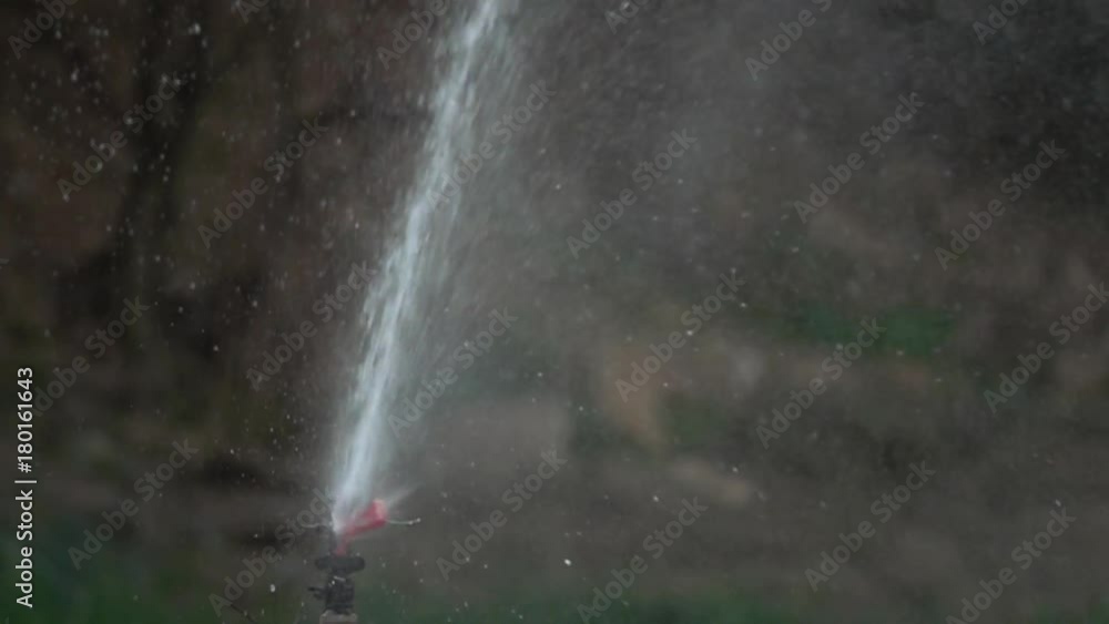 Watering the green grass. Sparkling water spraying out of sprinkler on