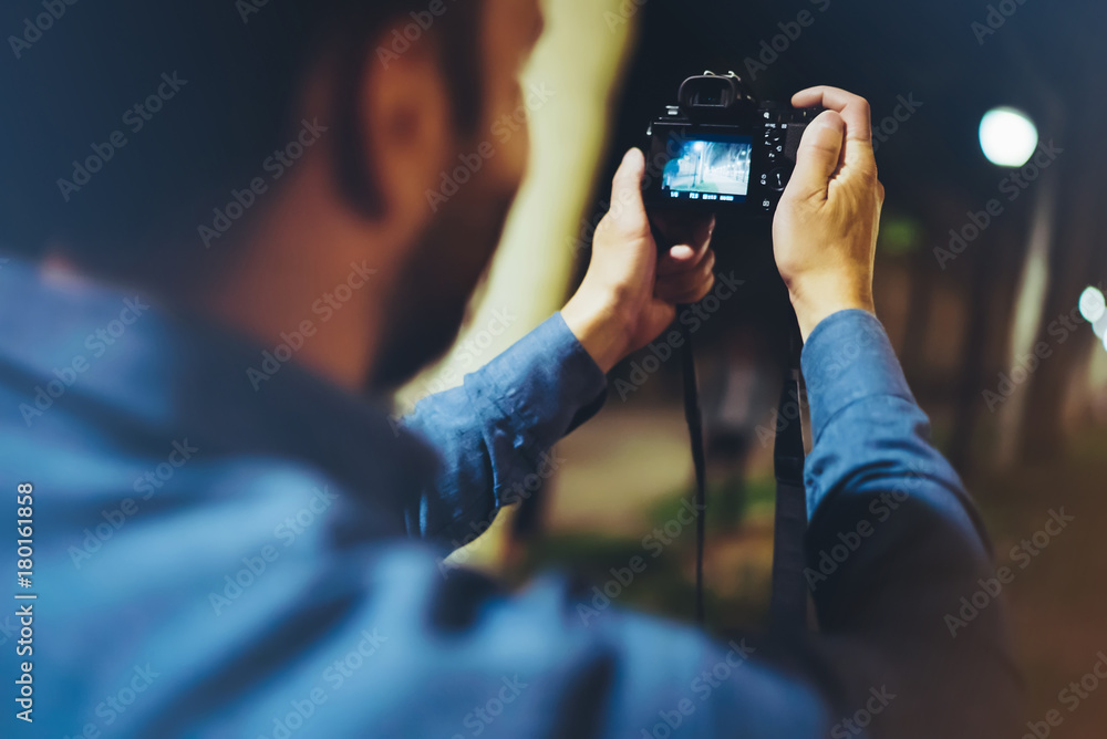 Hipster hiker tourist taking photo on camera on background of evening atmospheric city, photographer guy enjoying light of holiday, blurred traveler relax lifestyle concept, view night street Hipster hiker tourist taking photo on camera on background of evening atmospheric city, photographer guy enjoying light of holiday, blurred traveler relax lifestyle concept, view night street
