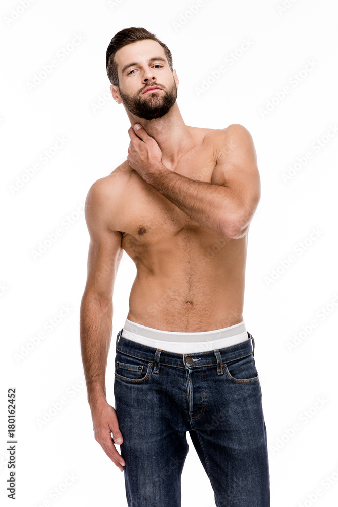 So sensual. Handsome shirtless young man in jeans looking at camera while standing against white background. So sensual. Handsome shirtless young man in jeans looking at camera while standing against white background.