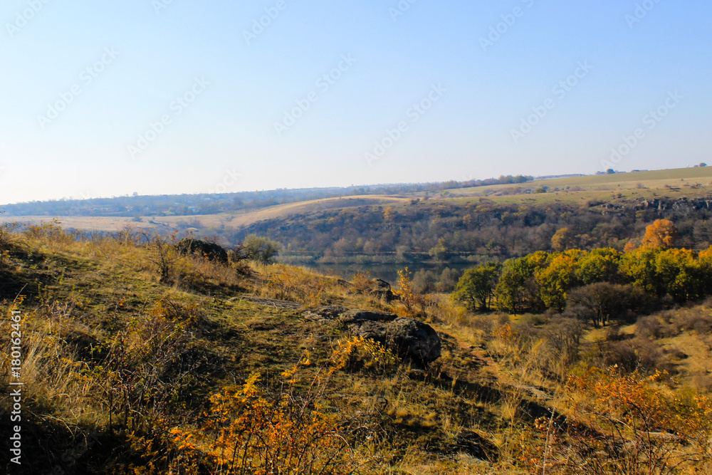 Autumn landscape with trees, hills and sky