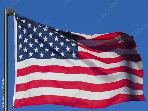 Flag of USA fluttering in the wind on a background of blue sky.
