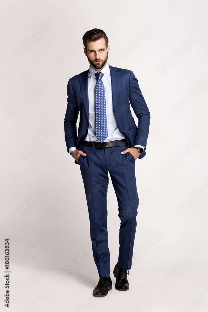Perfect suit. Full length of handsome young man in suit looking at camera while standing against white background. Perfect suit. Full length of handsome young man in suit looking at camera while standing against white background.