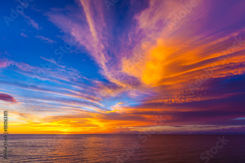 Stunning colorful sunset, blue sky, yellow purple cirrus clouds, orange sun, dark sea. Sunset on Jimbaran, South Kuta, Bali, Indonesia. © Valery Bocman