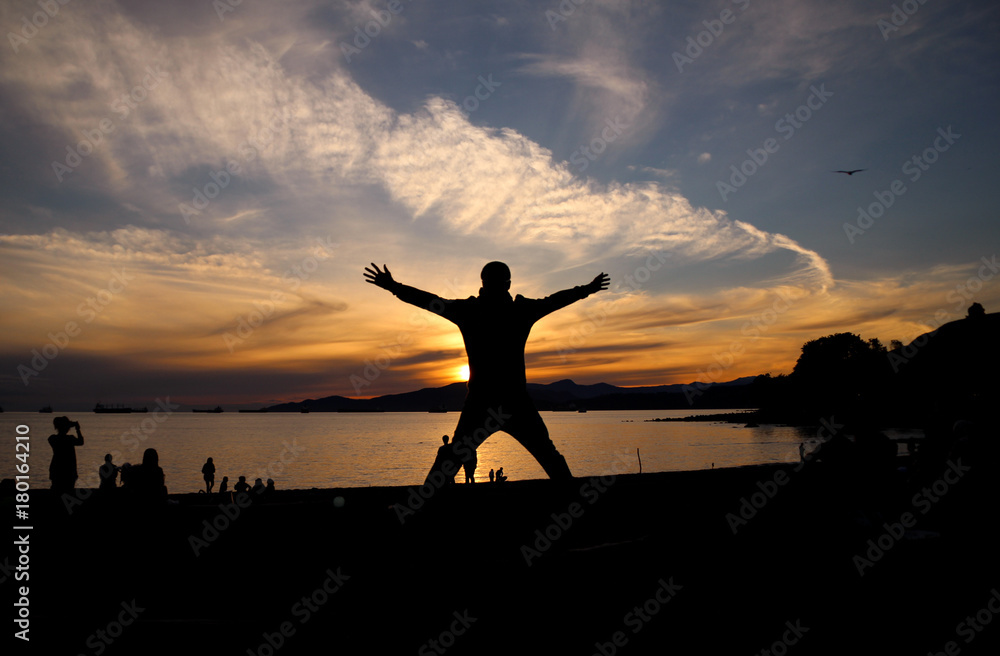 Silhouette of a guy jumping up at sunset