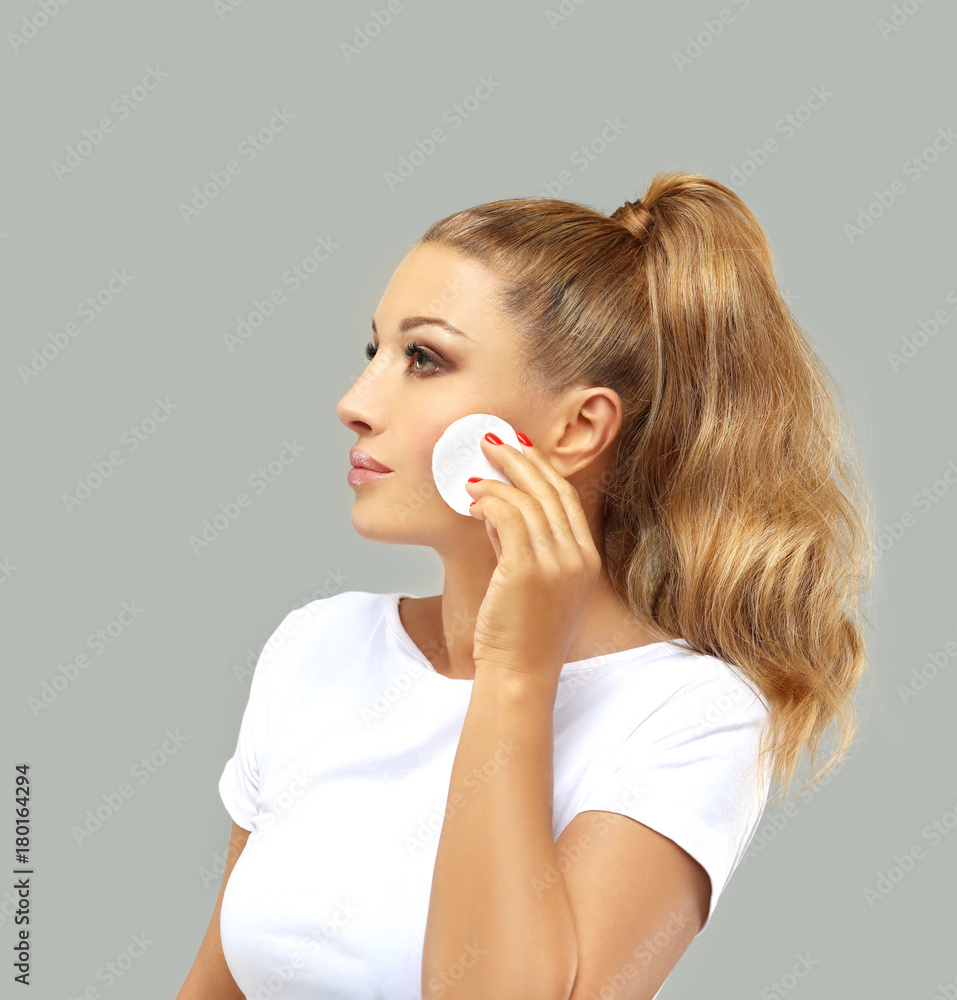 Beauty care woman using cotton pad , isolated on grey background. Skin care and beauty concept. Beauty care woman using cotton pad , isolated on grey background. Skin care and beauty concept.