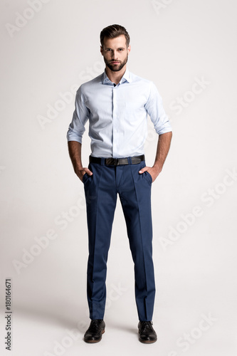 Confident and successful. Full length of handsome young man looking at camera while standing against white background.