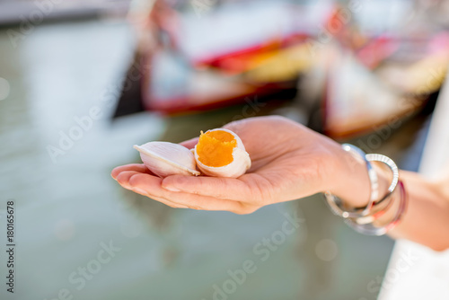 Holding portuguese delicacy called Ovos Moles made of egg yolks and sugar on the water channal background in Aveiro city, Portugal photo