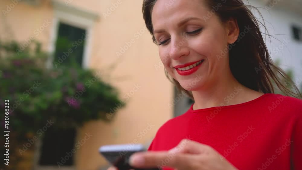 Happy woman talking on the smartphone while standing on the stairs outdoors Happy woman talking on the smartphone while standing on the stairs outdoors