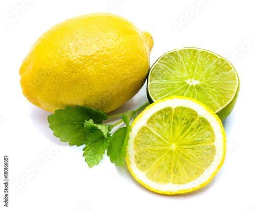 One whole yellow lemon, cross section lime half, lemon slice and fresh green lemon balm leaves isolated on white background .
