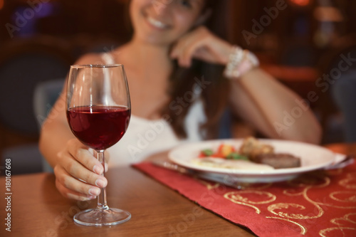 Woman drinking red wine in restaurant