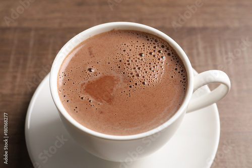 Cup with delicious cocoa drink on wooden background © Africa Studio