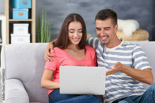 Young couple with laptop on...