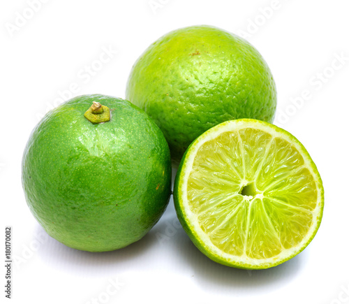 Two whole limes, one half isolated on white studio background.