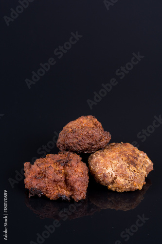 Meatballs isolated above black background with reflections and copy space