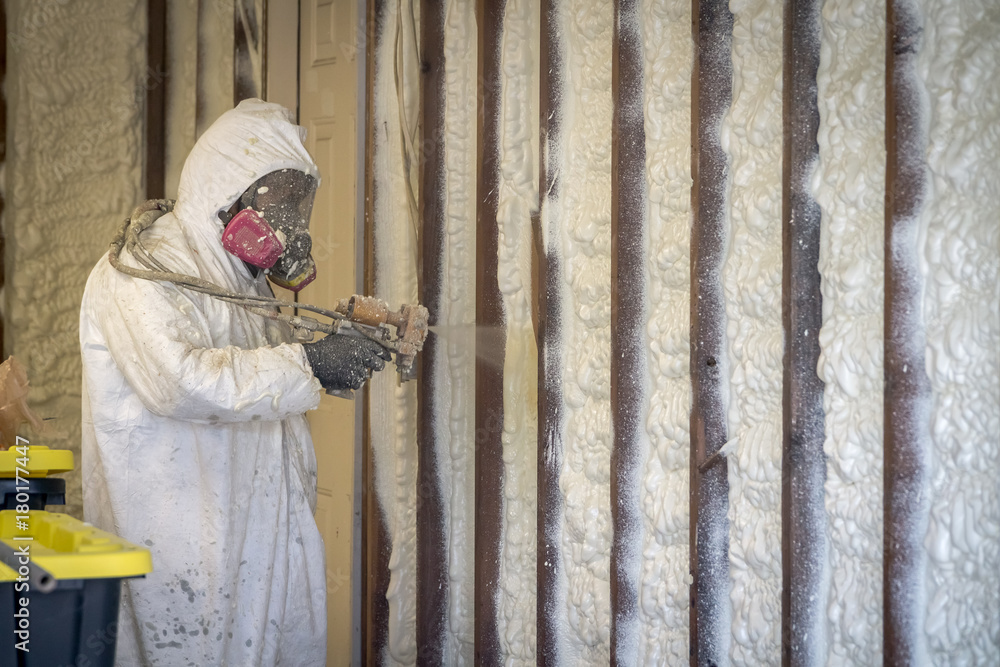 Worker spraying closed cell spray foam insulation on a home that was  flooded by Hurricane Harvey Photos | Adobe Stock