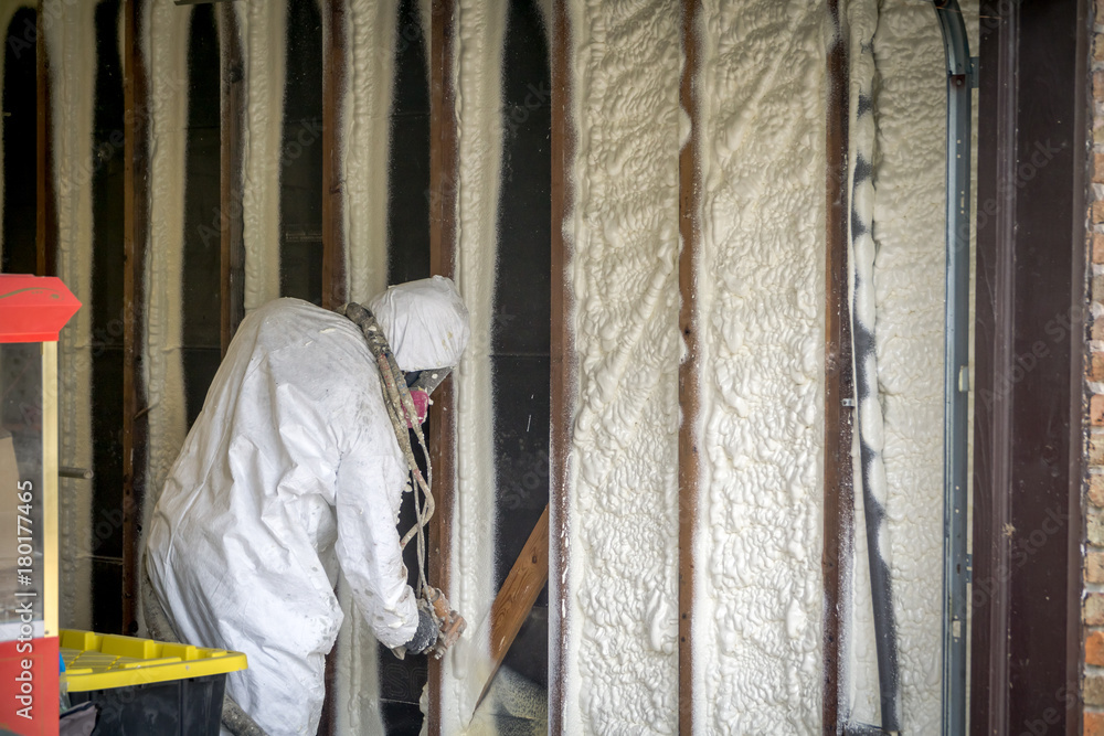 Worker spraying closed cell spray foam insulation on a home that was flooded by Hurricane Harvey Worker spraying closed cell spray foam insulation on a home that was flooded by Hurricane Harvey