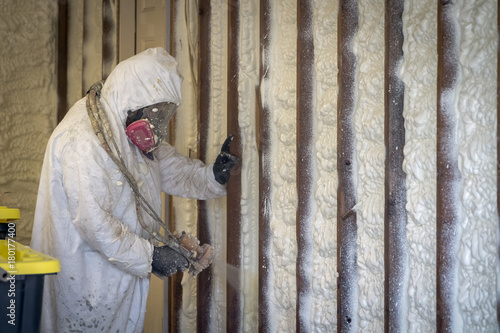 Worker spraying closed cell spray foam insulation on a home that was flooded by Hurricane Harvey