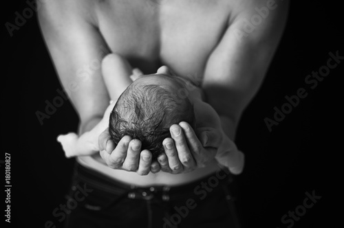 newborn in dad's hands black and white