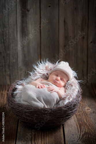 Newborn baby sleeping in the basket on blanket