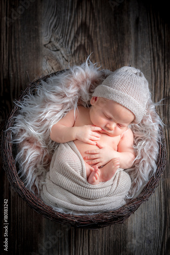 Newborn baby sleeping in the basket with blanket