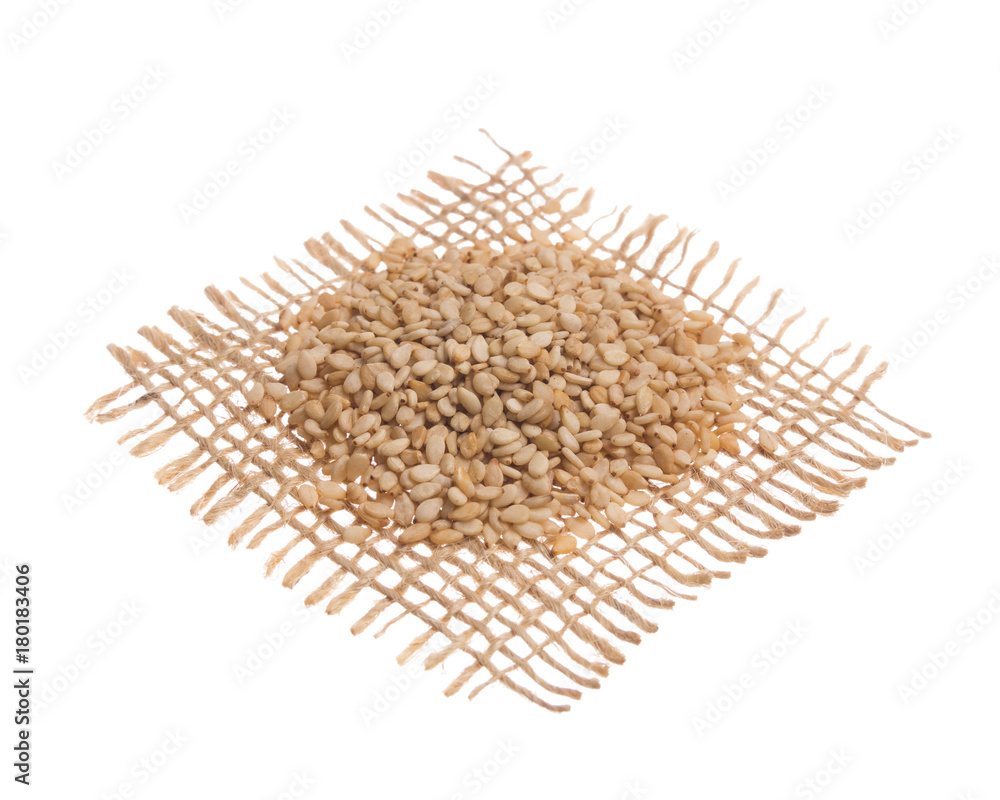Sesame. Grains over hessian fabric, isolated white background. Sesame. Grains over hessian fabric, isolated white background.