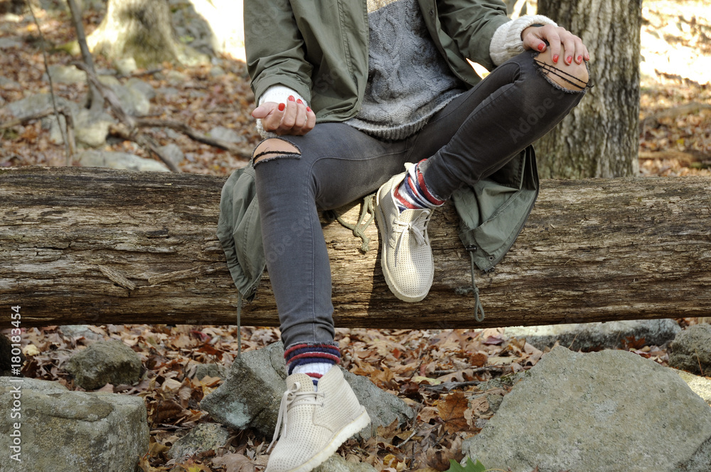 Girl is sitting in autumn forest in the mountains. Hiking and traveling Girl is sitting in autumn forest in the mountains. Hiking and traveling