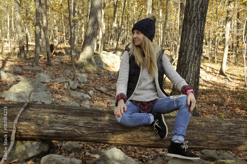 Girl is sitting in autumn forest in the mountains. Hiking and traveling Girl is sitting in autumn forest in the mountains. Hiking and traveling