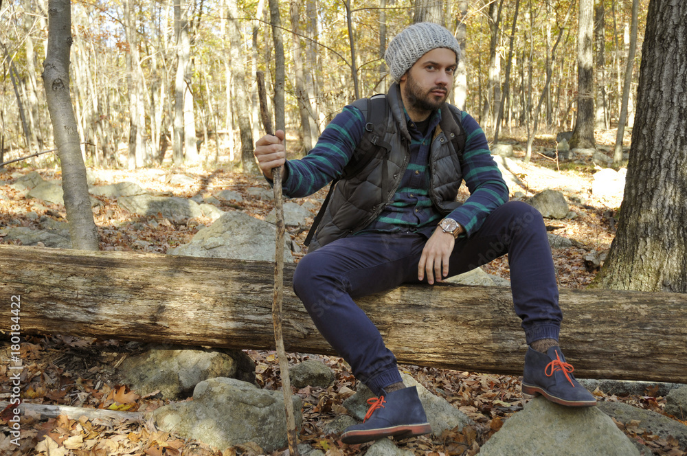 Man is sitting in autumn forest in the mountains. Hiking and traveling Man is sitting in autumn forest in the mountains. Hiking and traveling