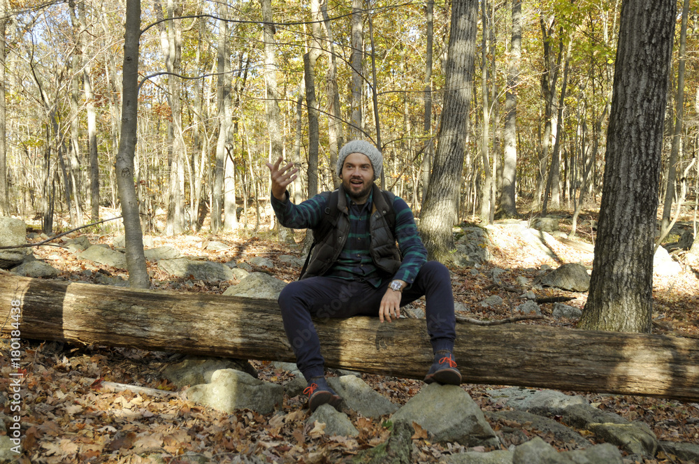 Man is sitting in autumn forest in the mountains. Hiking and traveling Man is sitting in autumn forest in the mountains. Hiking and traveling