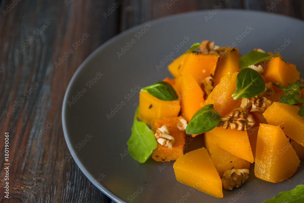 Salad with pumpkin, walnuts and green leaves