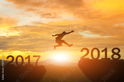Fototapeta Naklejka Na Ścianę i Meble -  Men jump over silhouette Happy New Year 2018