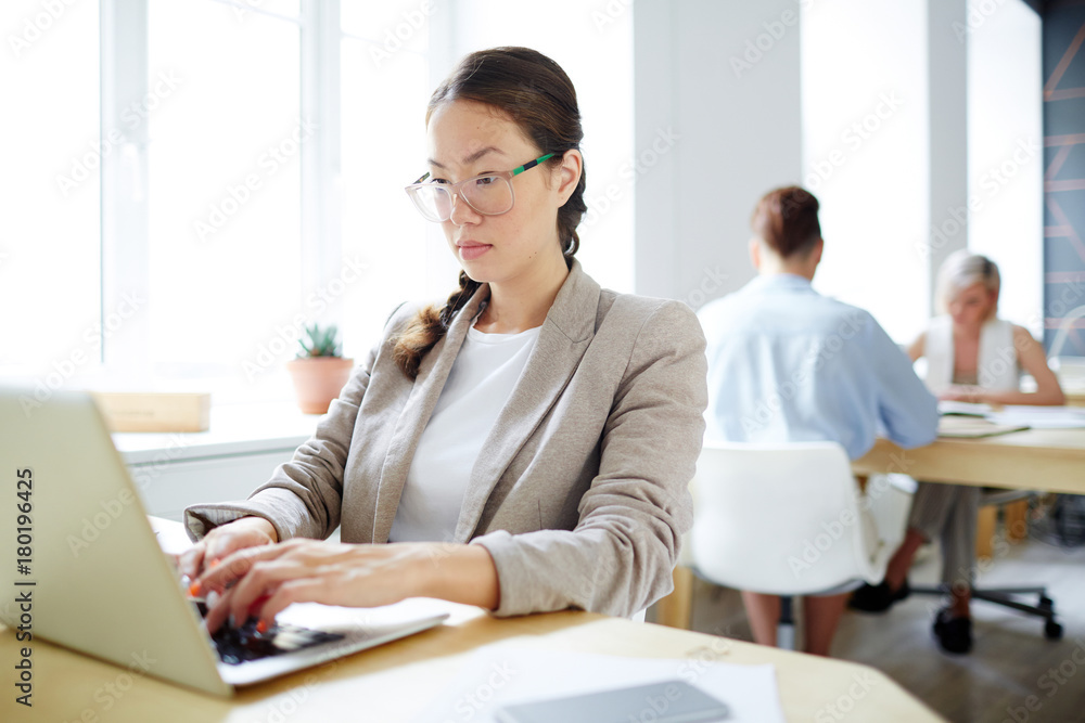 Young employee concentrating on reading online data and analyzing it Young employee concentrating on reading online data and analyzing it
