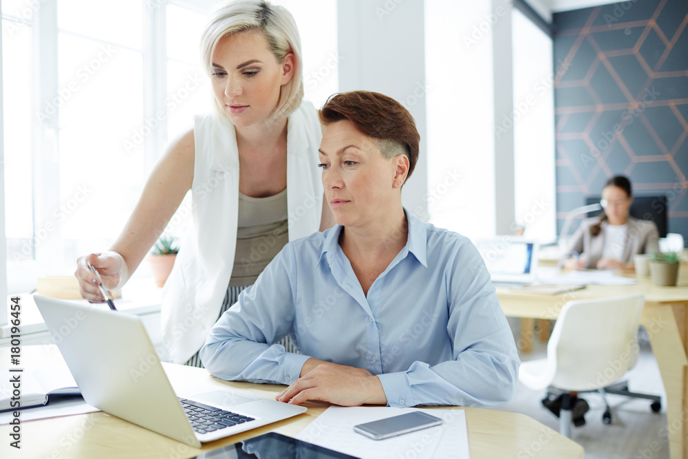 Fototapeta premium Two analysts discussing online sales rate and statistic data